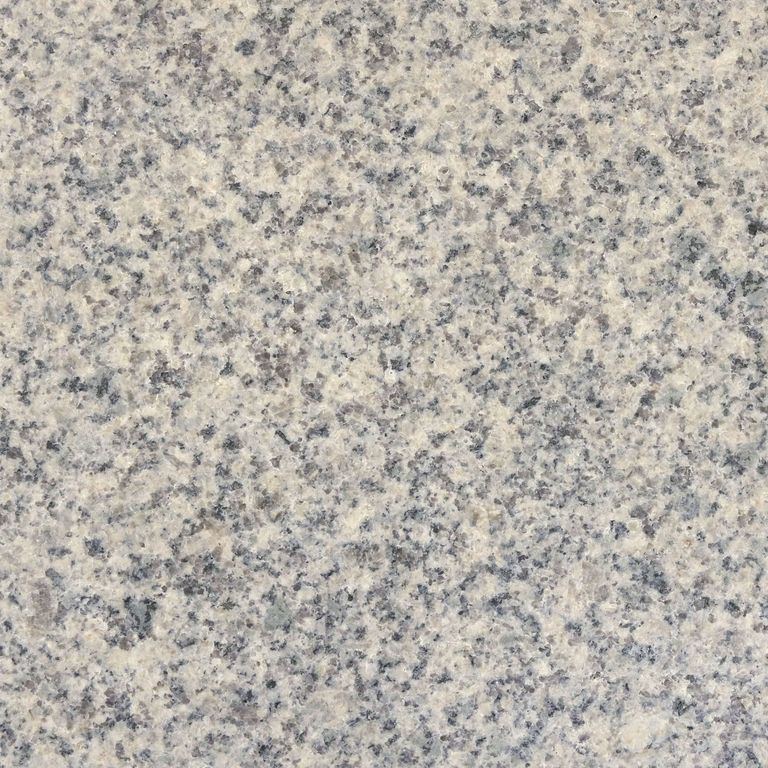 Color/Finish variation image for Cape Neddick Granite - Clear. The surface finish shown is leathered. Dominant colors shown are beige and gray; with purple, white, tan and cream secondaries. Speckled and coarse speckled color patterns.