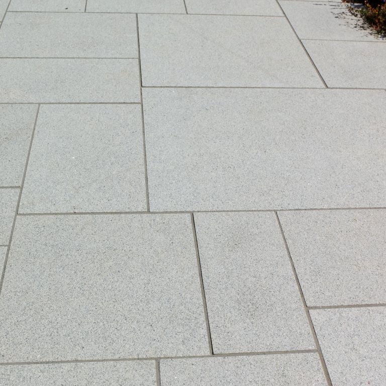 Application image for Granite - Cape Neddick Clear. The image shows this material being used in a patio pavers application. Dominant colors shown are beige and gray. The color mix creates a cool feeling. Fine speckled color pattern.