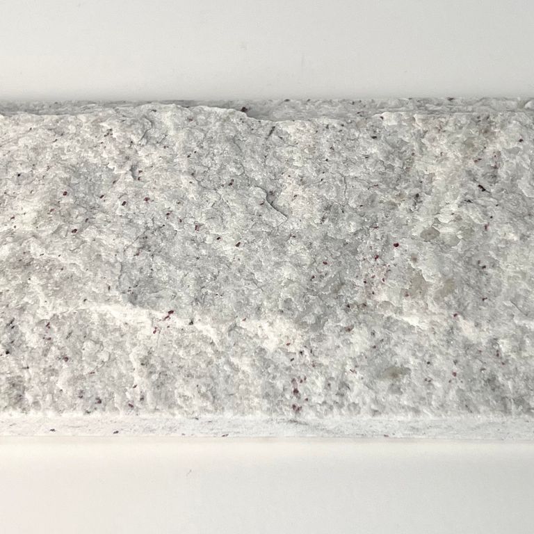Feature image for Gneiss - Yellow Grumari. The surface finish shown is rockfaced. The dominant color shown is white; with beige, white and cream secondaries. The color mix creates a warm feeling. Fine speckled and cloudy color patterns. Contains some mica and mineral inclusions.