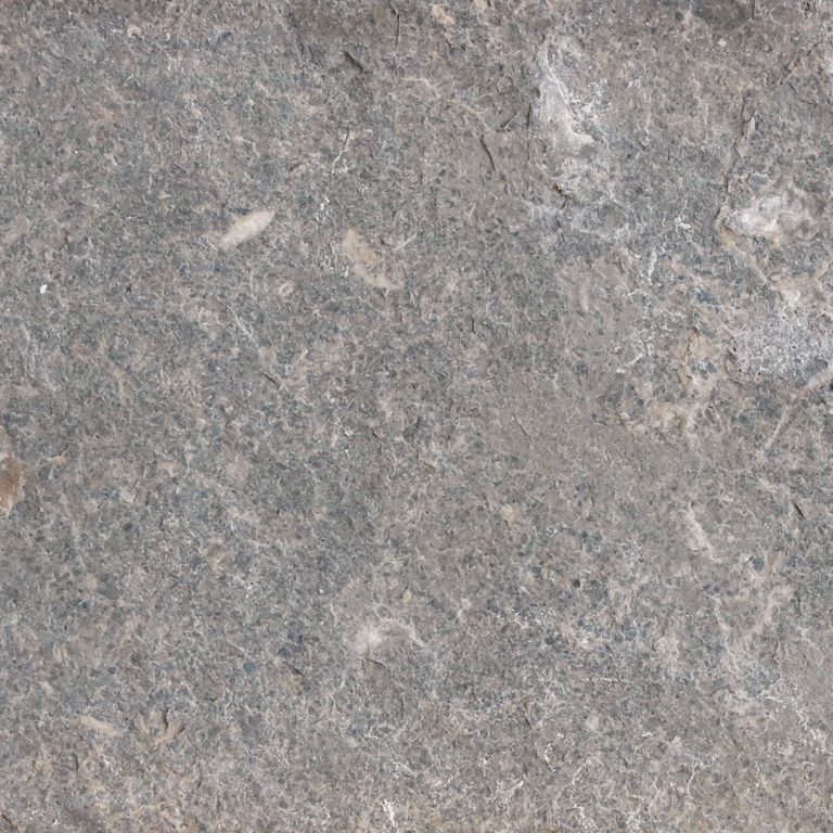 Best close-up image for Fossil Gray Limestone. The surface finish shown is flamed. The dominant color shown is gray; with beige, blue, green, purple and white secondaries. The color mix creates a cool feeling. Random color pattern. Contains mineral inclusions.