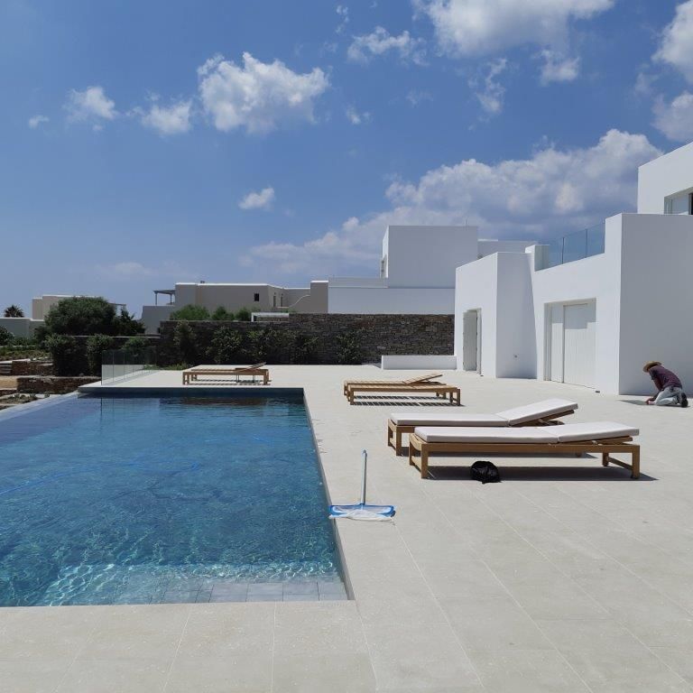 Application image for Veneto Olivo Limestone. The image shows this material being used for pool coping and pool deck pavers. The surface finish shown is flamed. The dominant color shown is gray. The color mix creates a cool feeling.
