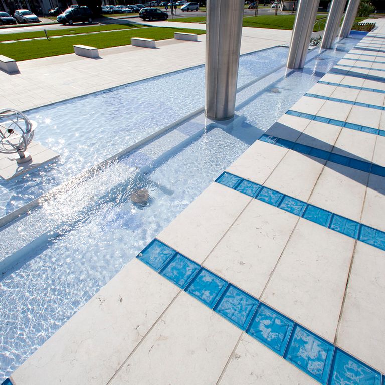 Application image for Limestone - Veneto Beige. The image shows this material being used for pool coping and path pavers. Dominant colors shown are beige and cream.