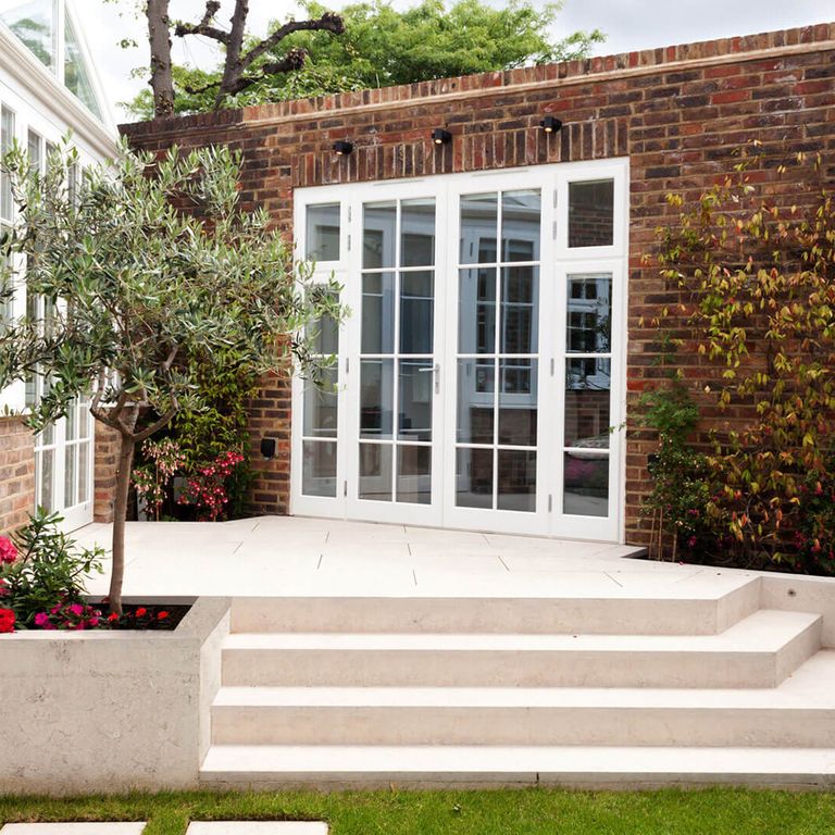 Feature image for Limestone - Veneto Rosato. The image shows this material being used for landscape wallstone, patio pavers and monolithic steps. The surface finish shown is flamed. Dominant colors shown are beige, gray, tan and cream; with brown, orange/rust, pink and white secondaries. The color mix creates a warm feeling. Cloudy color pattern.