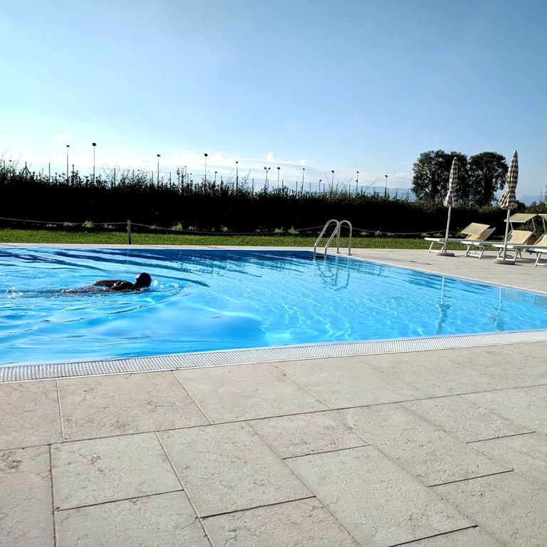 Application image for Limestone - Veneto Rosato. The image shows this material being used for pool coping and pool deck pavers. The surface finish shown is flamed. The dominant color shown is gray. The color mix creates a cool feeling.