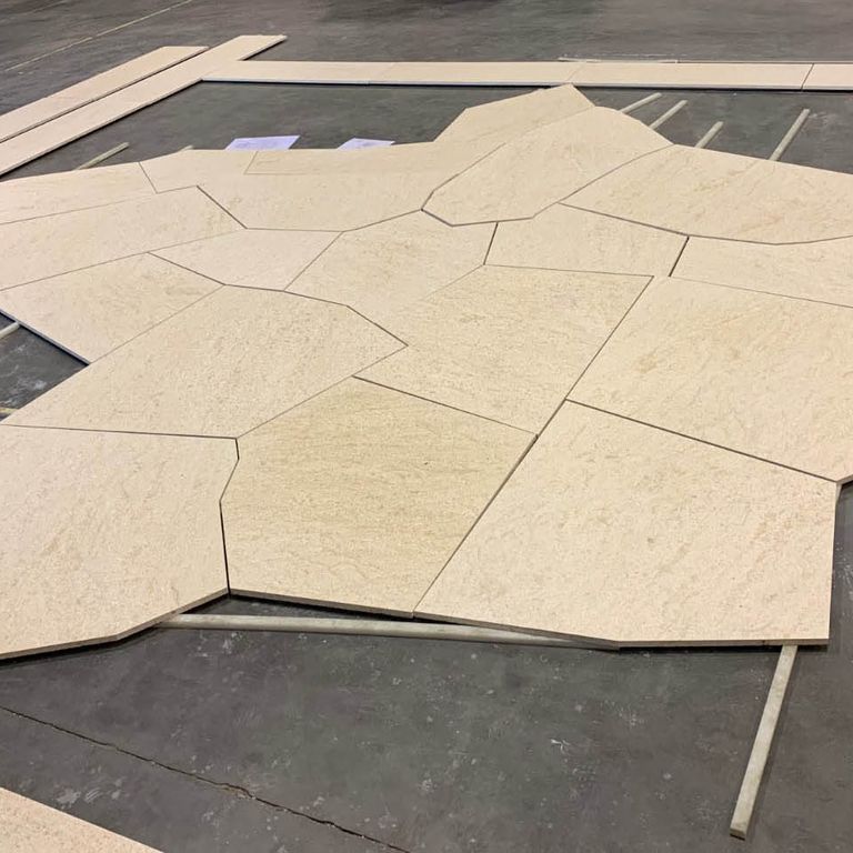 Feature image for Domus Gold Sandstone. The image shows this material being used in a patio pavers application. The surface finish shown is honed. Dominant colors shown are beige and tan; with orange/rust, yellow and cream secondaries. The color mix creates a warm feeling. Random color pattern. Contains voids.
