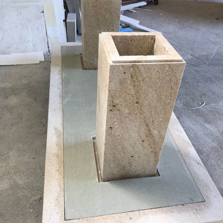 Application image for Domus Gold Sandstone. The image shows this material being used in a seating & benches application. The surface finish shown is honed. Dominant colors shown are brown, orange/rust and tan; with gray and purple secondaries. Exhibits 