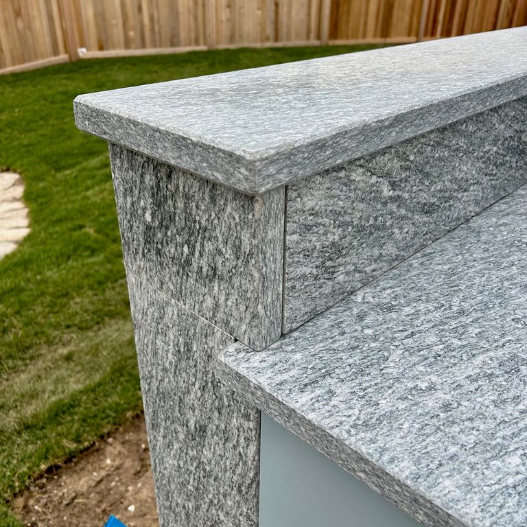 Application image for Pietra Italia Blue/Gray Gneiss. The image shows this material being used in a countertop slabs application. The surface finish shown is honed. The dominant color shown is gray. The color mix creates a cool feeling.