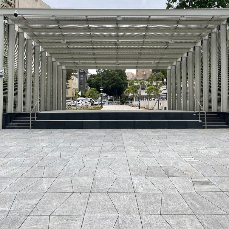 Feature image for Pietra Italia Gneiss - Blue. The image shows this material being used in a patio pavers application. The surface finish shown is flamed. Dominant colors shown are blue, gray and white. The color mix creates a cool feeling. Regular color pattern.