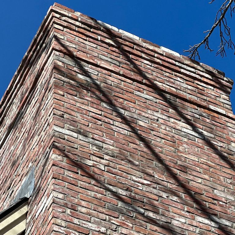 Feature image for Reclaimed Rail Station Brick. The image shows this material being used for full bed veneer and chimney. The surface finish shown is . Dominant colors shown are brown, gray, red and white. The color mix creates a warm feeling. Regular color pattern.