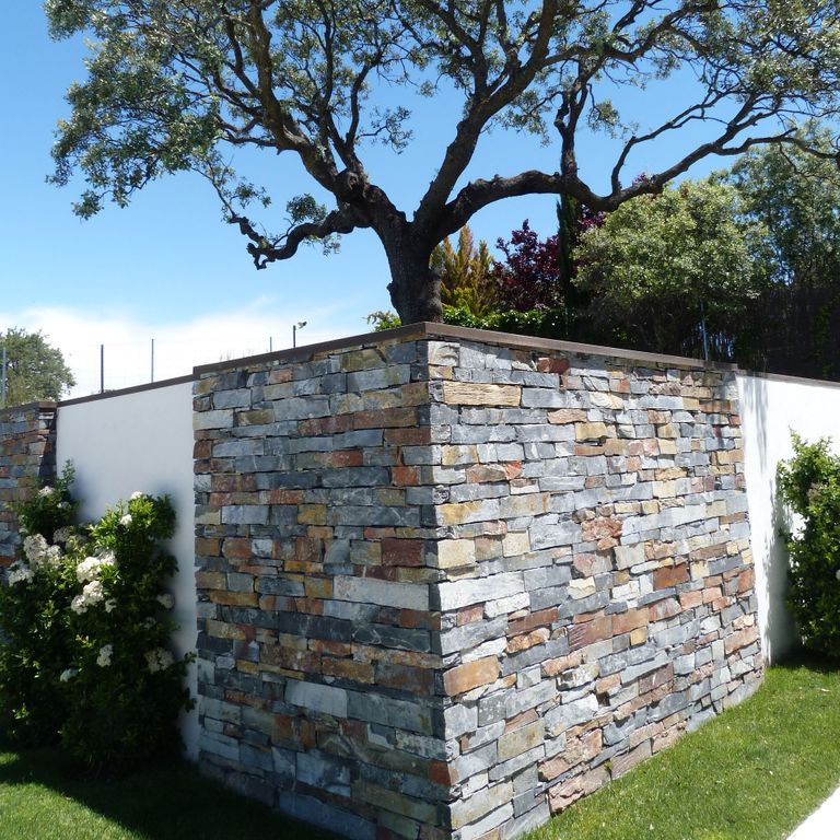Application image for Iberian Gray Slate. The image shows this material being used in a full bed veneer application. The surface finish shown is split-face. Dominant colors shown are blue, gray and tan. Random color pattern.