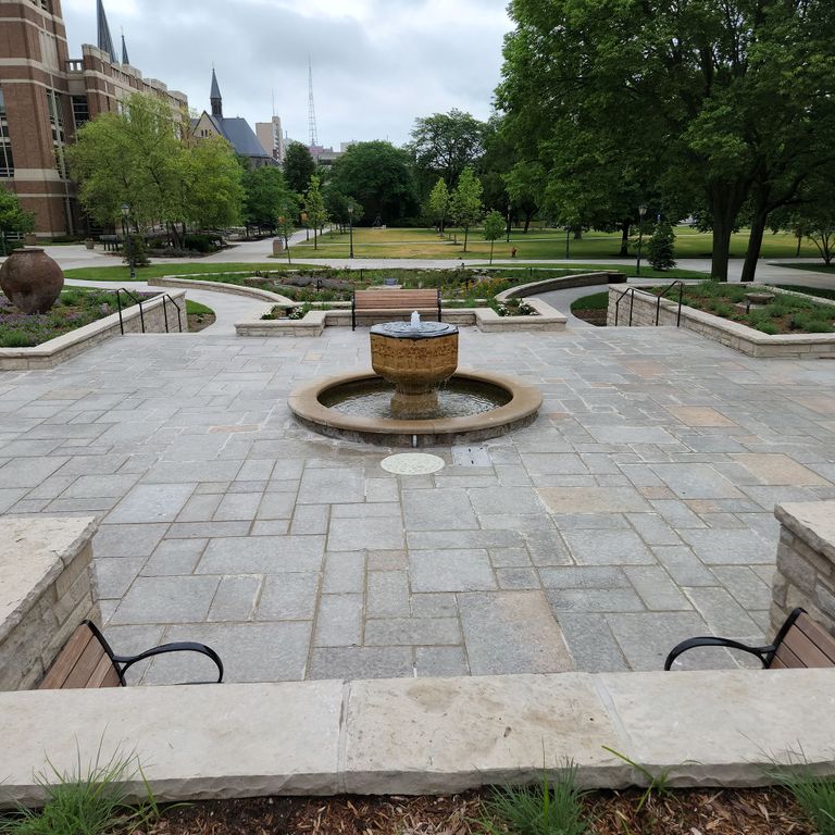 Application image for Limestone - Madison - Full Color. The image shows this material being used in a patio pavers application. The surface finish shown is flamed. Dominant colors shown are gray and tan. The color mix creates a warm feeling. Regular color pattern.