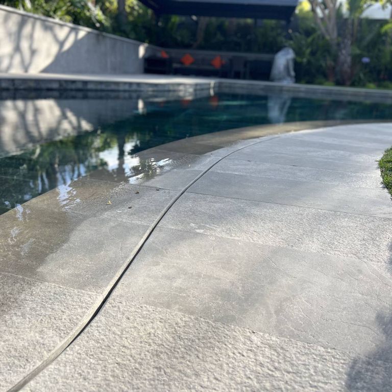 Application image for Limestone - Casablanca. The image shows this material being used in a pool coping application. The dominant color shown is gray. The color mix creates a cool feeling.