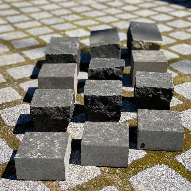 Application image for Basalt - Black Moon. The image shows this material being used in a patio pavers application. Dominant colors shown are black and gray. The color mix creates a warm feeling.