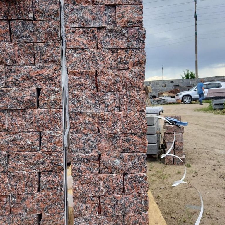Application image for Granite - Red Crystal. The image shows this material being used in a full bed veneer application. Dominant colors shown are gray and red. The color mix creates a warm feeling.