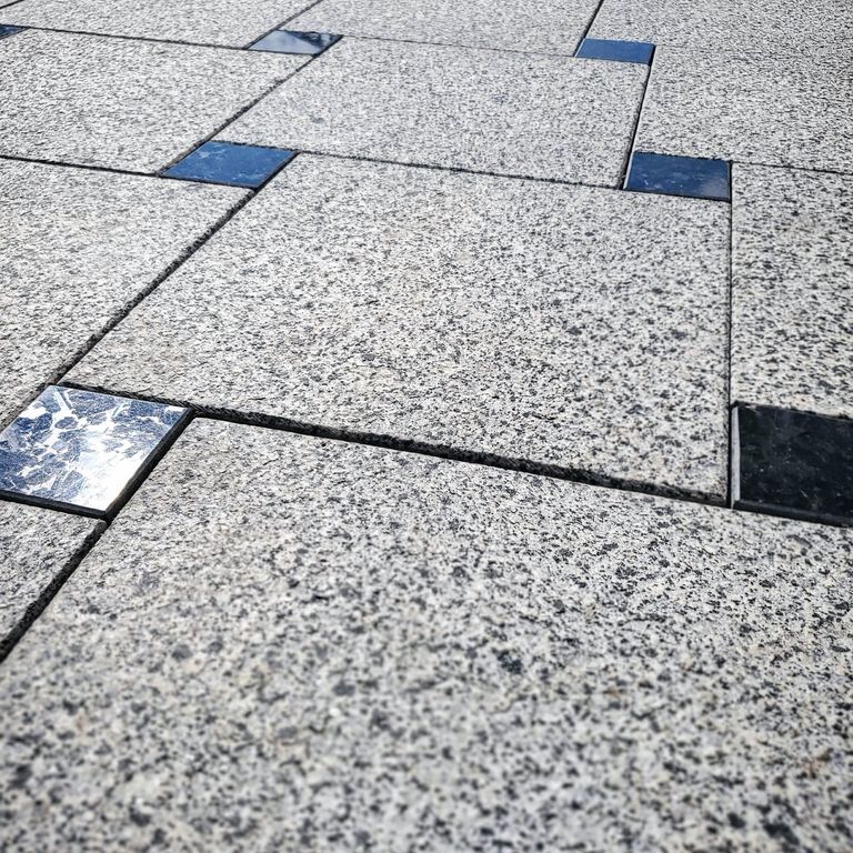 Application image for Granite - White House. The image shows this material being used in a patio pavers application. Dominant colors shown are gray and white. The color mix creates a cool feeling.
