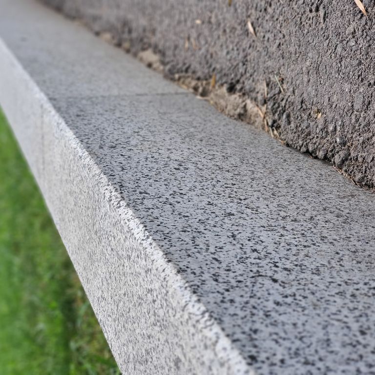 Application image for Granite - White House. The image shows this material being used in a landscape curbing & edging application. Dominant colors shown are gray and white. The color mix creates a cool feeling.