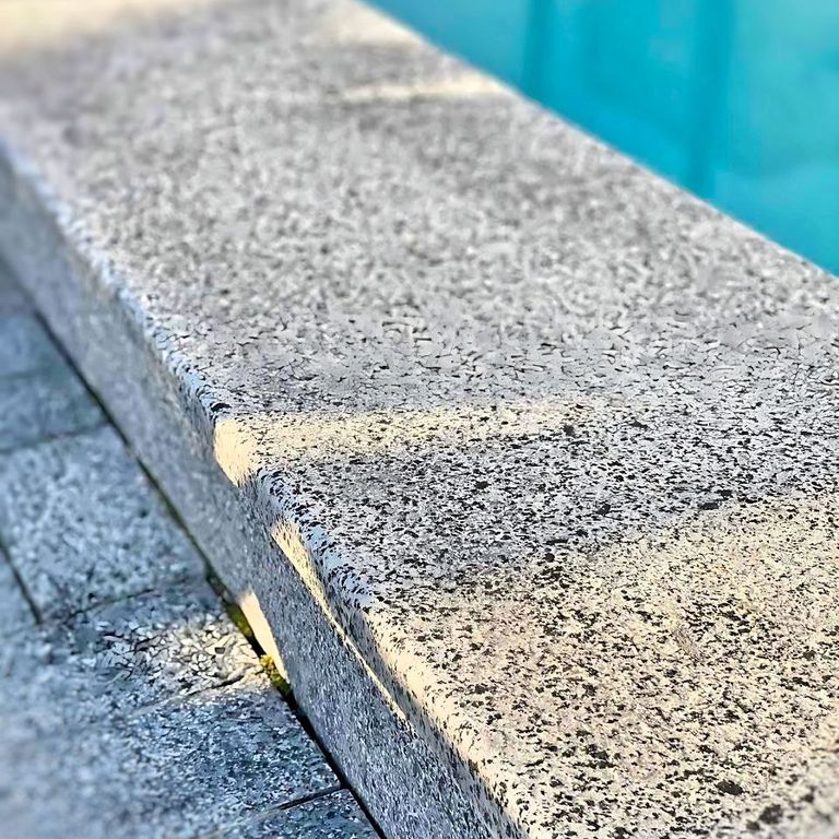 Application image for Granite - White House. The image shows this material being used in a pool coping application. Dominant colors shown are gray and white. The color mix creates a cool feeling.