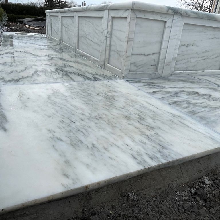 Application image for Marble - White Cloud. The image shows this material being used for pool coping and thin veneer. The dominant color shown is white. The color mix creates a cool feeling.