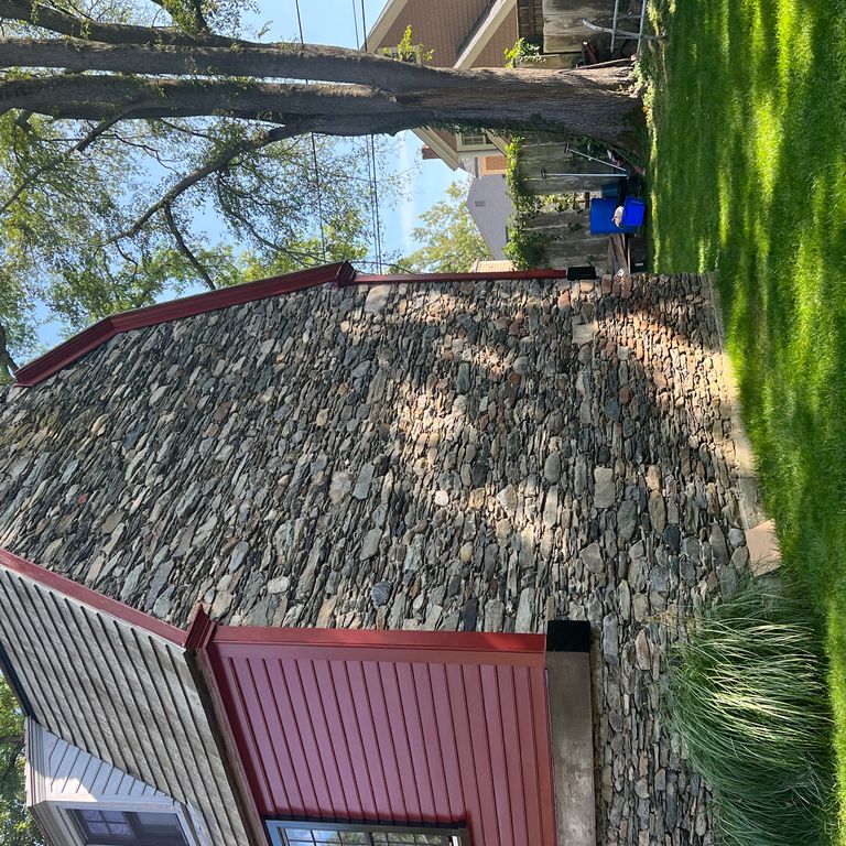Application image for Fieldstone - New England Flats. The image shows this material being used in a landscape wallstone application. The surface finish shown is weathered. The dominant color shown is gray. The color mix creates a warm feeling.