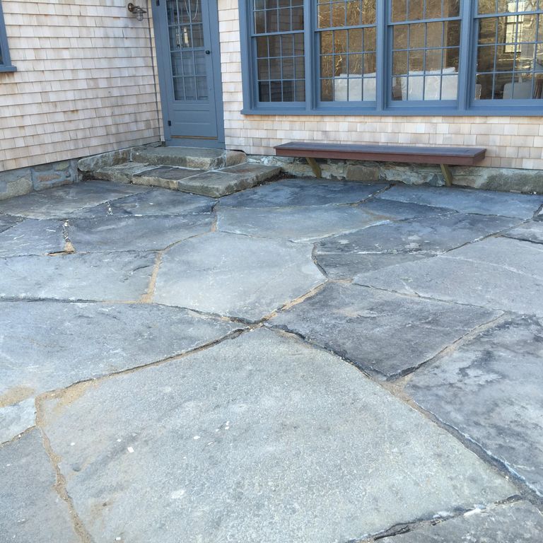 Application image for Granite - Reclaimed New England Quarry Tailings. The image shows this material being used in a patio pavers application. Dominant colors shown are blue and gray; with a white secondary. The color mix creates a cool feeling. Regular color pattern.