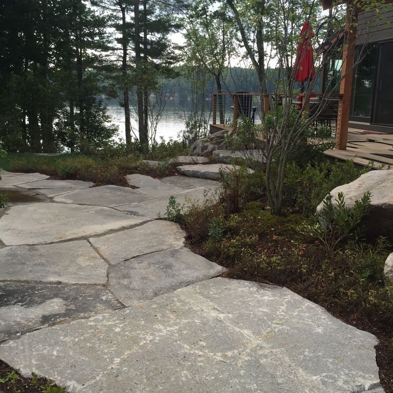 The image shows this material being used for path pavers and monolithic steps. Dominant colors shown are black and gray; with blue, brown and orange/rust secondaries.