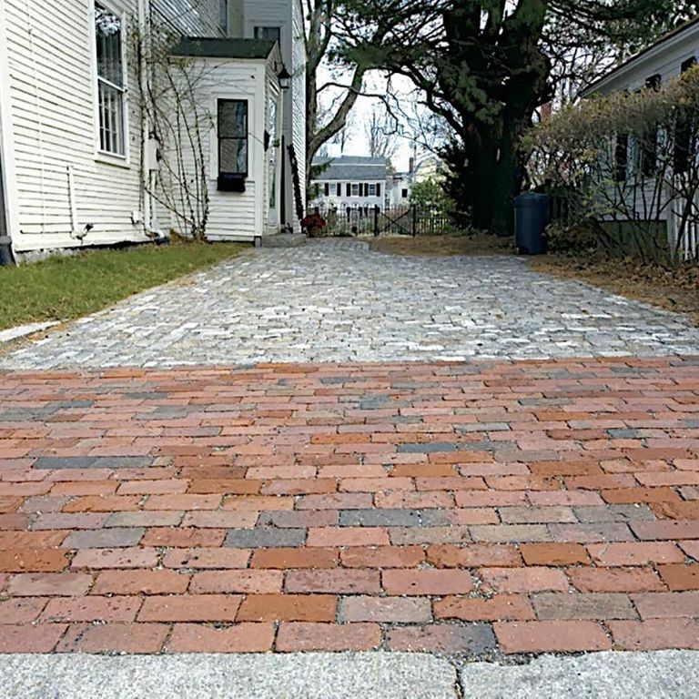 Application image for Reclaimed Brick. The image shows this material being used in a path pavers application. The surface finish shown is . Dominant colors shown are gray, pink and red. The color mix creates a warm feeling. Regular color pattern.