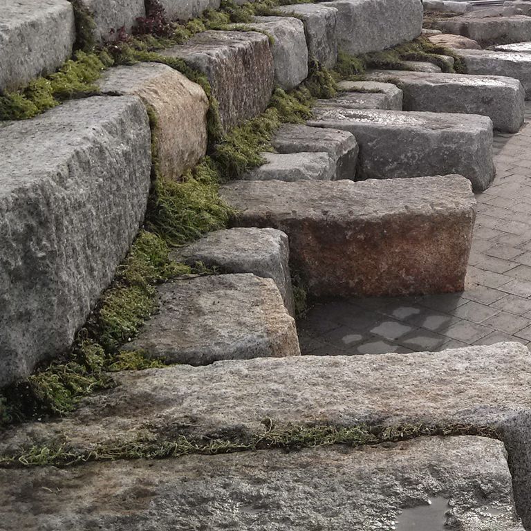 Application image for Reclaimed Granite Block. The image shows this material being used in a seating & benches application. The dominant color shown is gray. The color mix creates a warm feeling.