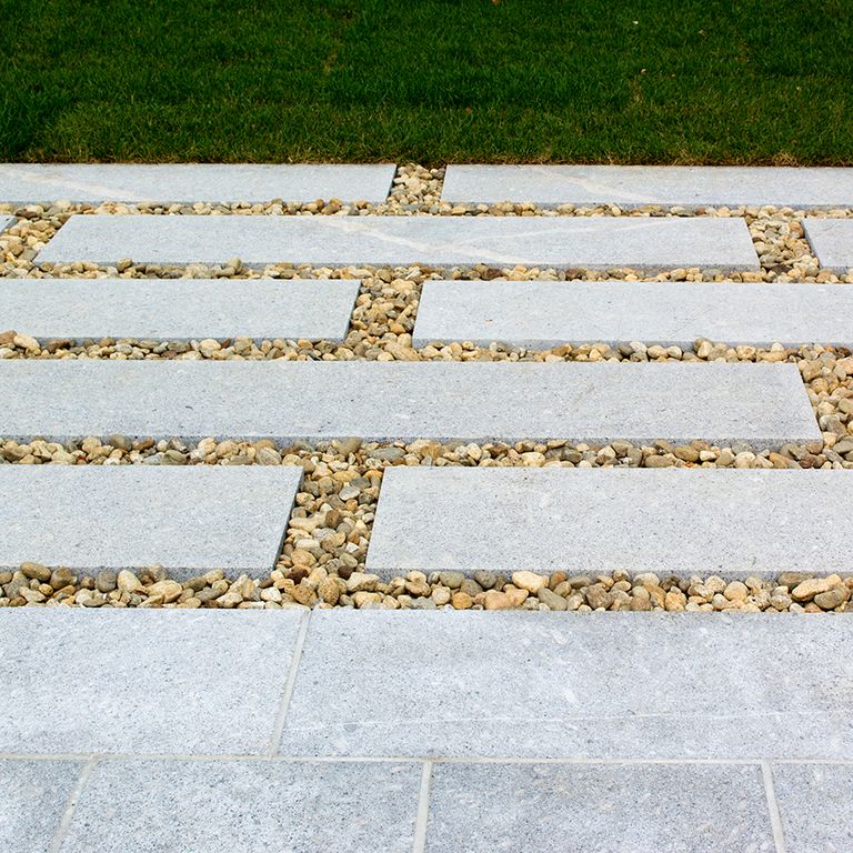 Feature image for Oak Mountain Granite. The image shows this material being used in a patio pavers application. The design pattern shown is dimensional squares and rectangles. The dominant color shown is gray; with a white secondary. The color mix creates a cool feeling. Solid and fine speckled color patterns.