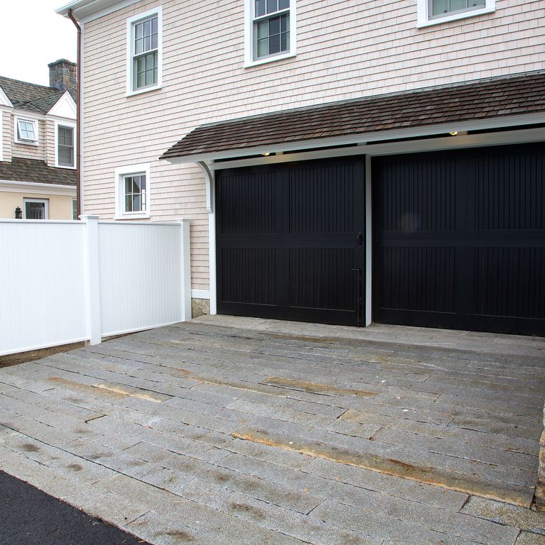 The image shows this material being used in a driveway pavers application. The dominant color shown is gray; with beige and brown secondaries.