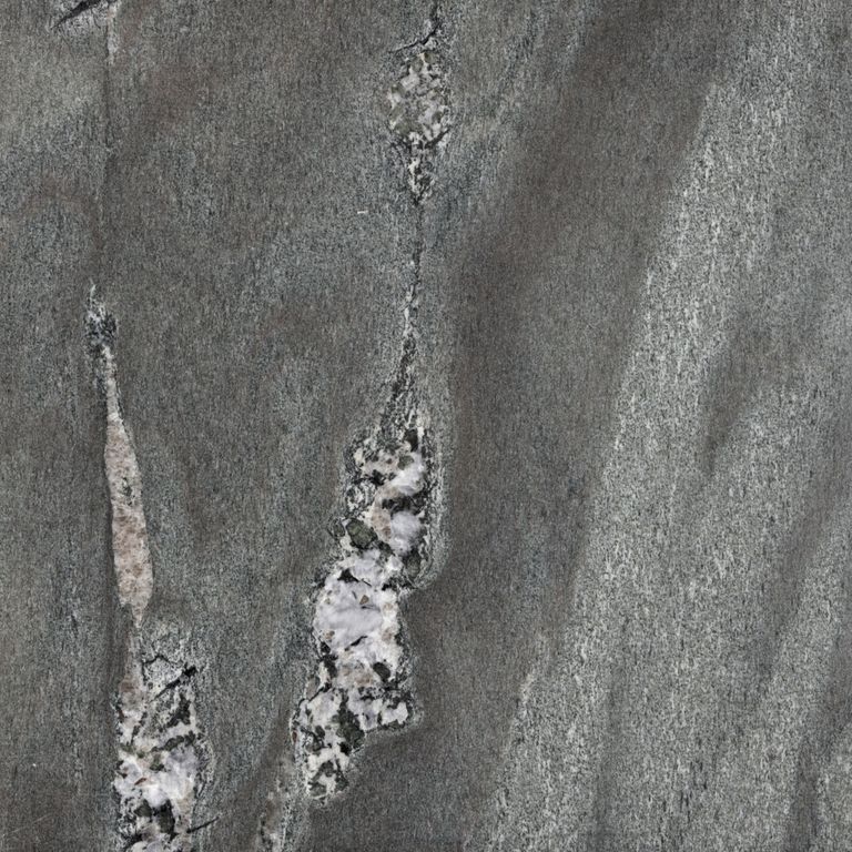 Color/Finish variation image for Granite - Mystic Mountain- Flamed. The surface finish shown is polished. Dominant colors shown are green and gray; with black, brown, purple and white secondaries. Exhibits 