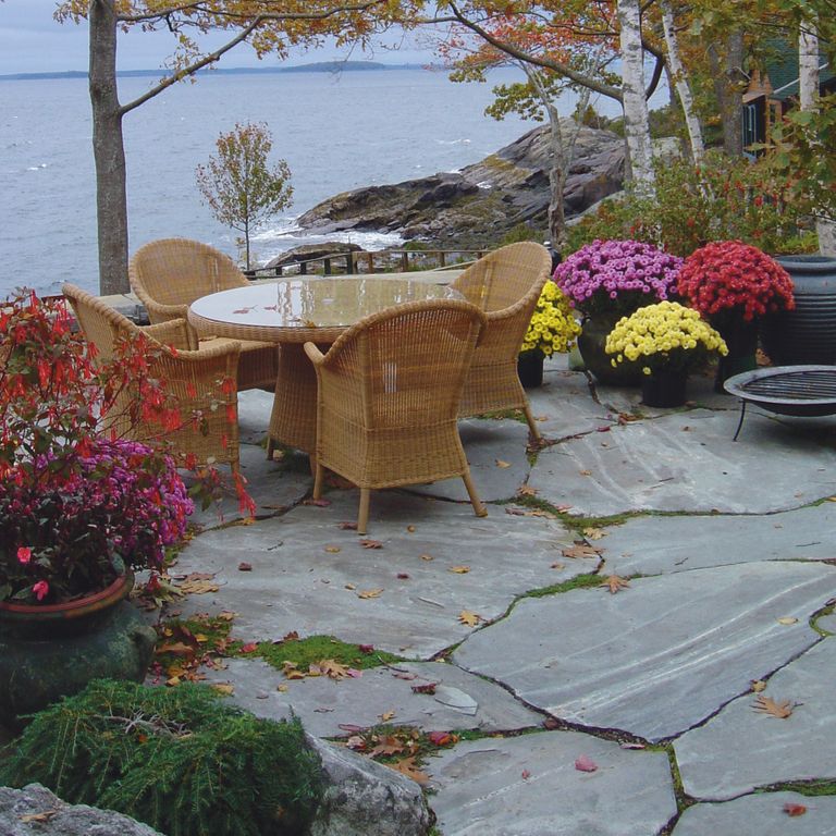 Feature image for Granite - Mystic Mountain- Flamed. The image shows this material being used in a patio pavers application. Dominant colors shown are blue and gray; with green, purple and white secondaries. The color mix creates a cool feeling. Linear, streaked and random color patterns.