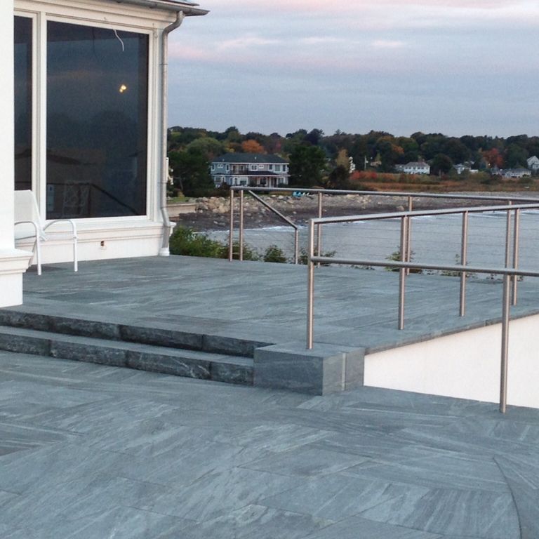 The image shows this material being used for patio pavers and monolithic steps. Dominant colors shown are blue and gray; with black, white and cream secondaries. The color mix creates a cool feeling. Streaked color pattern.
