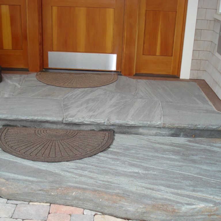 The image shows this material being used for landings and monolithic steps. Dominant colors shown are brown and gray; with blue, orange/rust and white secondaries. Linear color pattern.