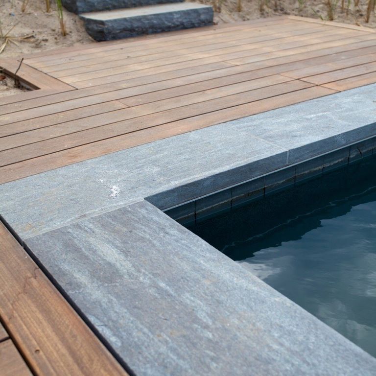 Application image for Mystic Mountain - Worked Surface. The image shows this material being used in a pool coping application. The surface finish shown is flamed. Dominant colors shown are blue and gray. Streaked color pattern.