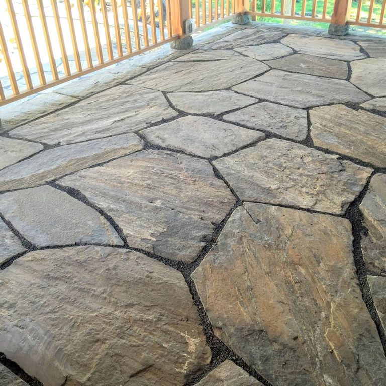 The image shows this material being used in a patio pavers application. Dominant colors shown are brown and gray; with beige, orange/rust and tan secondaries. The color mix creates a warm feeling. Regular and linear color patterns.