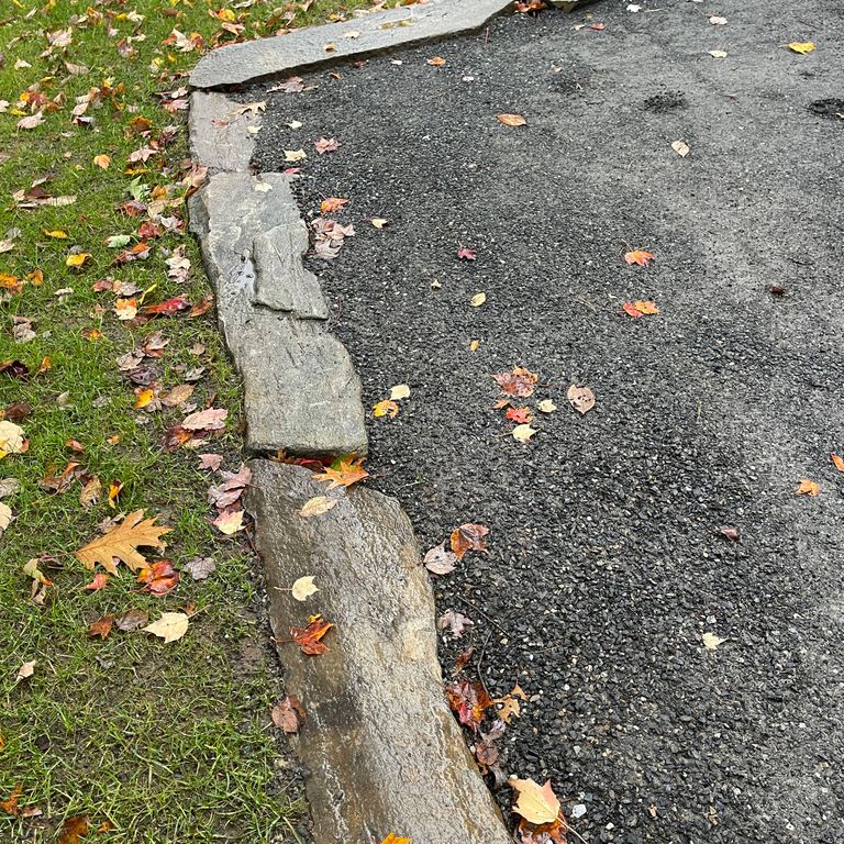 Application image for Mystic Mountain - Natural. The image shows this material being used in a landscape curbing & edging application. The surface finish shown is natural. The dominant color shown is gray; with beige, white and tan secondaries. The color mix creates a cool feeling. Regular color pattern.
