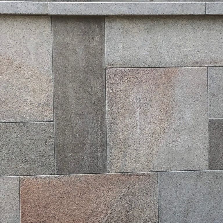 The image shows this material being used for wallstone cap and full bed veneer. The dominant color shown is gray; with blue, brown, green, orange/rust, purple, white and tan secondaries.