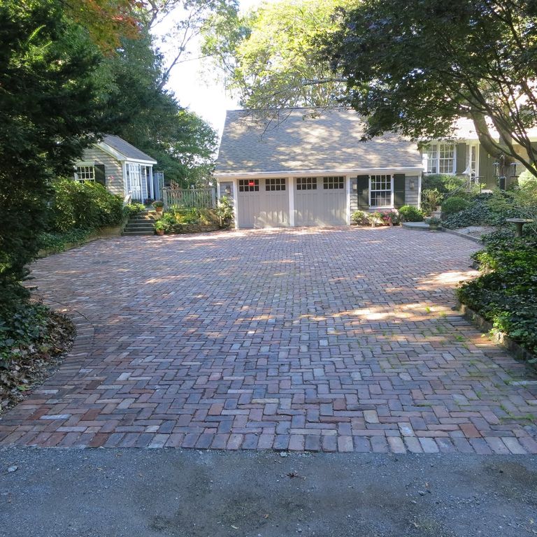The image shows this material being used in a driveway pavers application. The dominant color shown is brown.