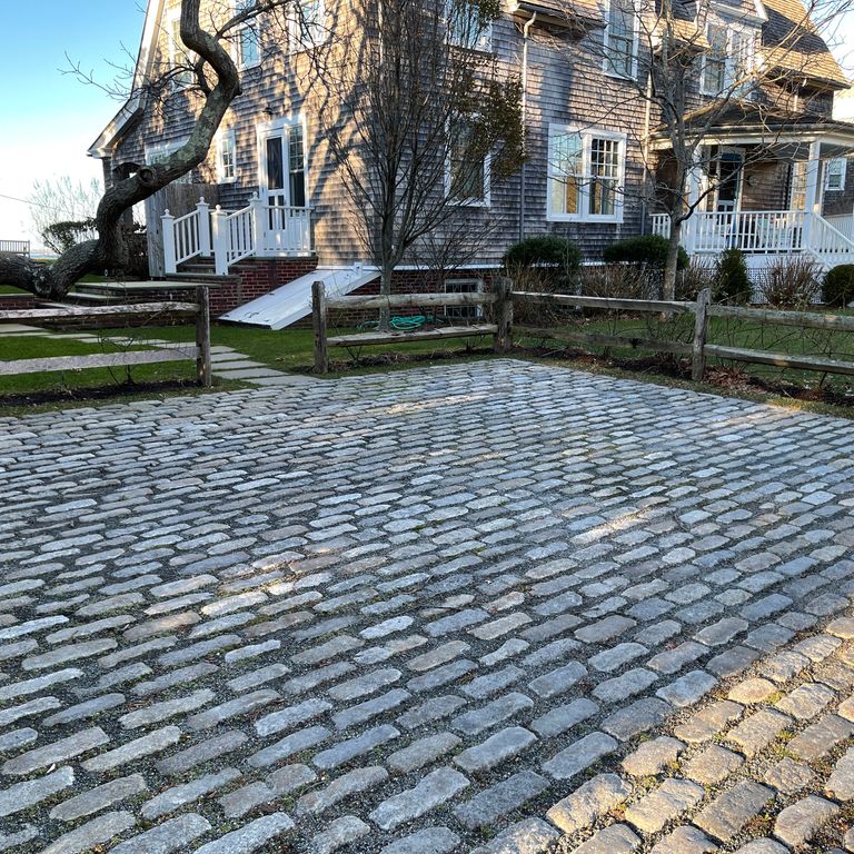 The image shows this material being used in a driveway pavers application.