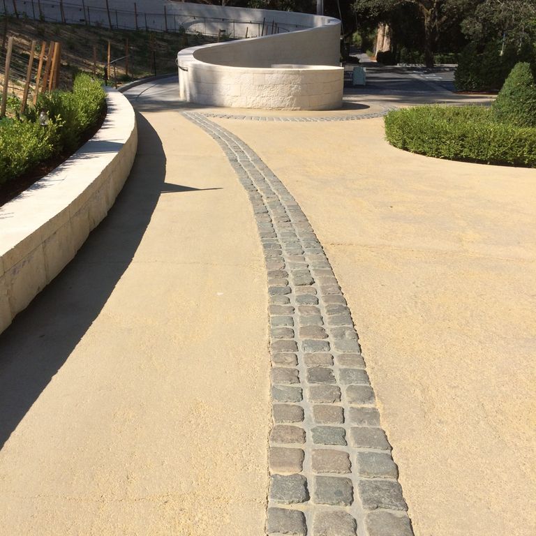 Application image for Reclaimed European Porphyry Cobblestones. The image shows this material being used in a public area application. The surface finish shown is . The dominant color shown is gray. The color mix creates a warm feeling.