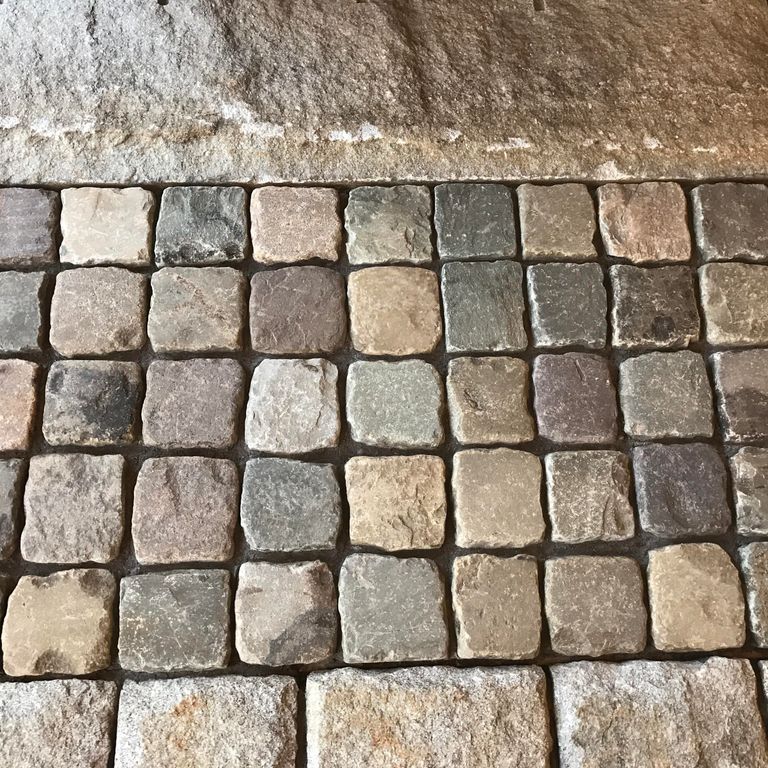 Application image for Reclaimed European Sandstone Cobblestones. The image shows this material being used in a path pavers application. The surface finish shown is . Dominant colors shown are brown, gray and tan. The color mix creates a warm feeling.