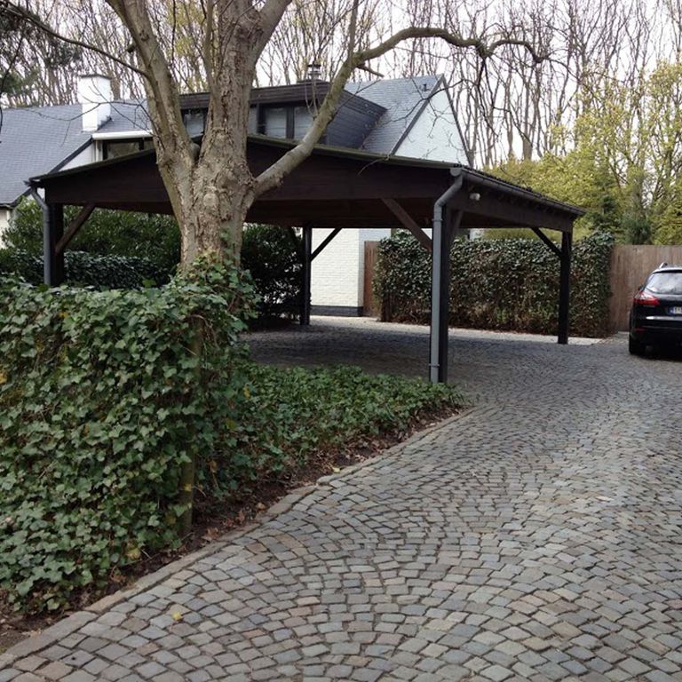 Application image for Reclaimed European Sandstone Cobblestones. The image shows this material being used in a driveway pavers application. The surface finish shown is . The dominant color shown is gray; with blue, brown, purple, white and tan secondaries. The color mix creates a warm feeling. Regular color pattern.