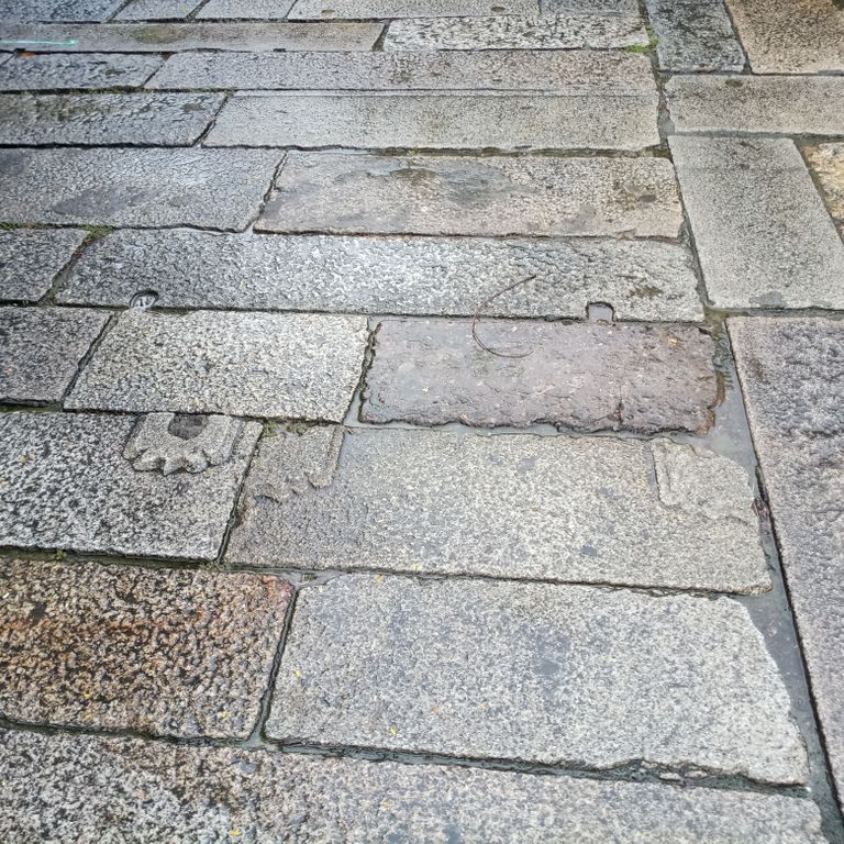 Application image for Reclaimed Footworn Granite Planks. The image shows this material being used in a path pavers application. The dominant color shown is gray. The color mix creates a warm feeling.