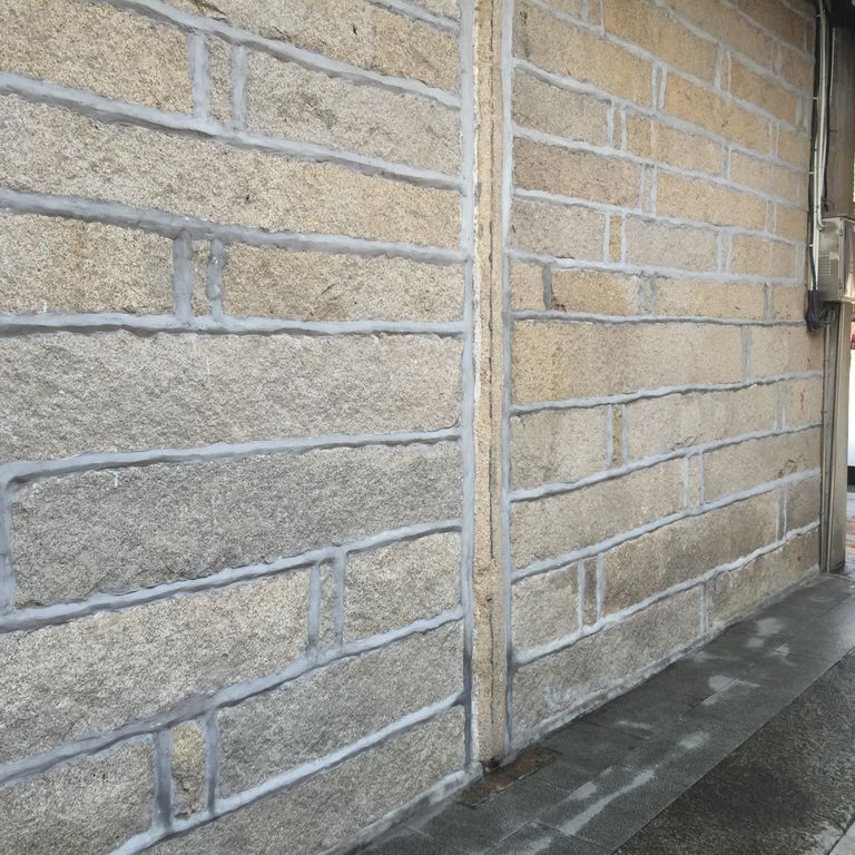Feature image for Reclaimed Granite Plank Veneer. The image shows this material being used in a full bed veneer application. The dominant color shown is gray; with beige, brown, orange/rust, purple, white and tan secondaries. Speckled and fine speckled color patterns.