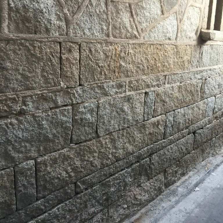 Application image for Reclaimed Granite Plank Veneer. The image shows this material being used in a full bed veneer application. The surface finish shown is . The dominant color shown is gray. The color mix creates a warm feeling. Regular color pattern.