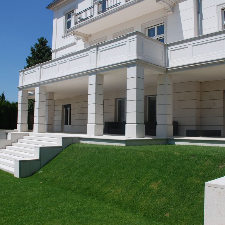 Application image for Mountain Hard Limestone - Beige. The image shows this material being used for wallstone cap, landscape wallstone, columns, monolithic steps and full bed veneer. The surface finish shown is honed. Dominant colors shown are gray and pink. The color mix creates a cool feeling. Solid color pattern.