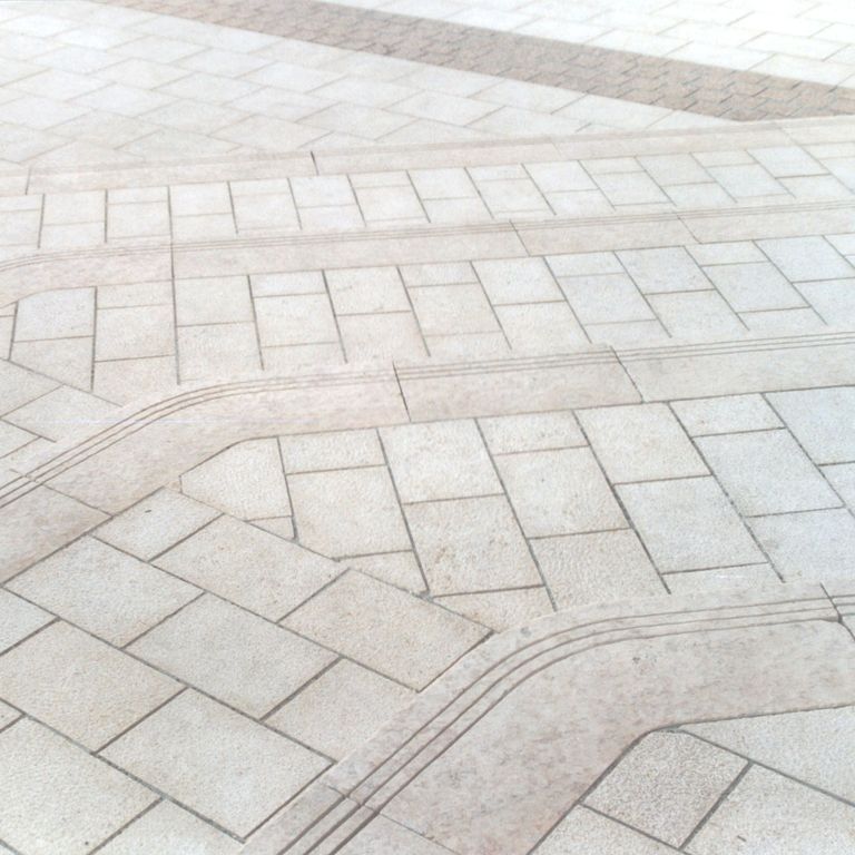 Application image for Mountain Hard Limestone - Beige. The image shows this material being used in a patio pavers application. The surface finish shown is flamed. Dominant colors shown are beige, gray and pink. The color mix creates a cool feeling. Regular color pattern.