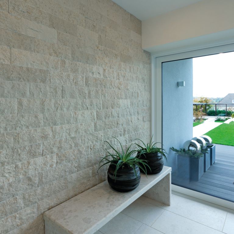 Application image for Limestone - Mountain Hard Beige. The image shows this material being used for interior floor, full bed veneer, thin veneer and interior cladding. The surface finish shown is a combination of brushed and split-face. Dominant colors shown are blue and pink. The color mix creates a cool feeling. Solid color pattern.