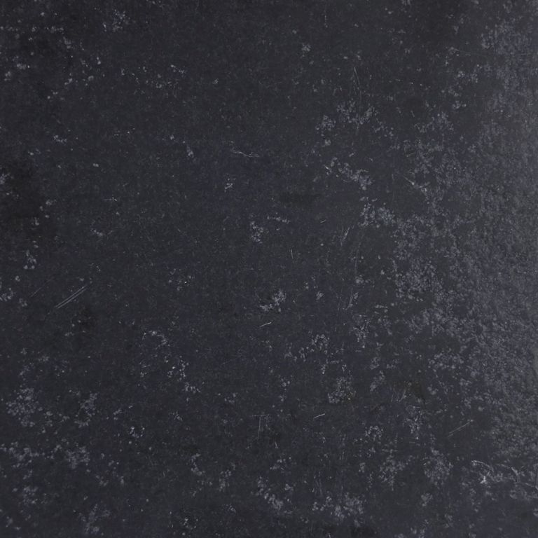 Close-up image for Bahama Black Limestone. The surface finish shown is antiqued. The dominant color shown is black; with blue and gray secondaries. Exhibits 