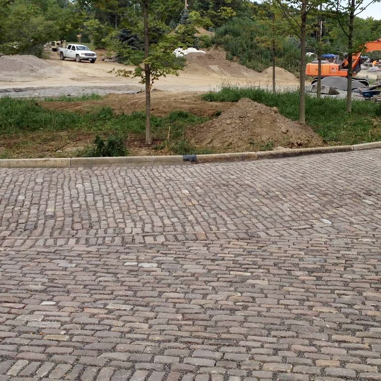The image shows this material being used in a driveway pavers application.
